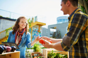 Woman Purchasing Tomatoes at Farmers Market Stall